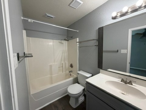 A bathroom with a toilet, sink, and shower.