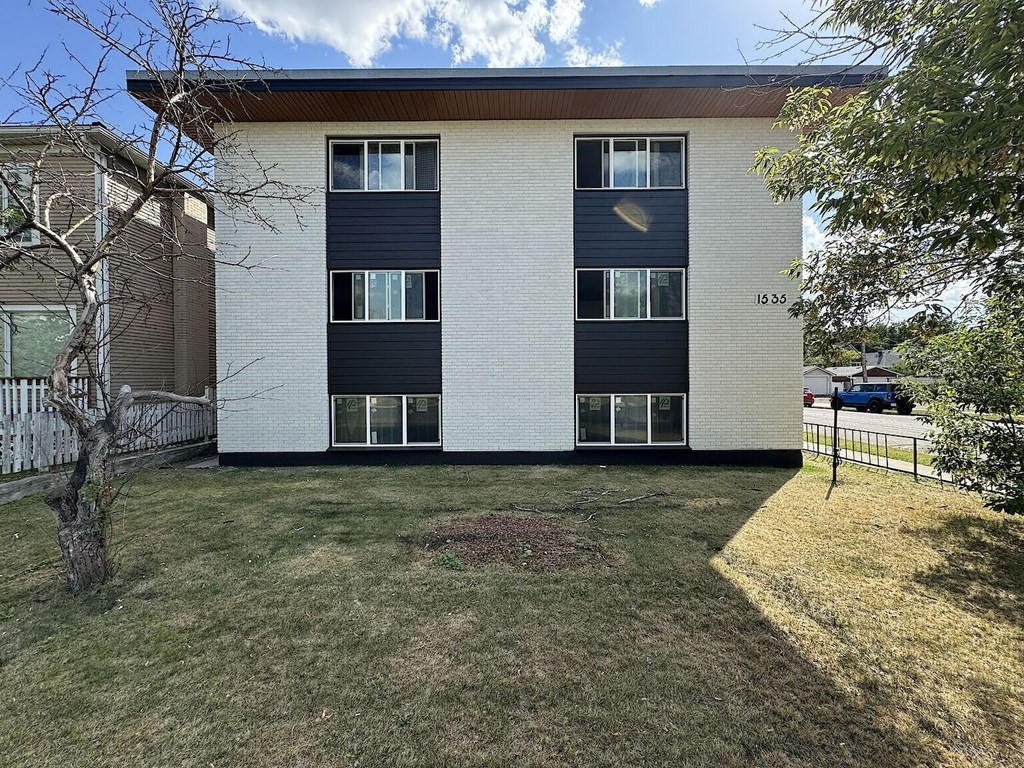 A modern two-story apartment building with a white and black exterior.
