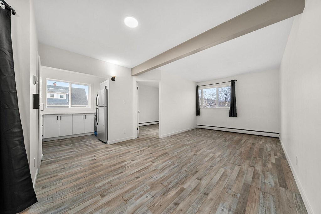 A room with wooden flooring and white walls.
