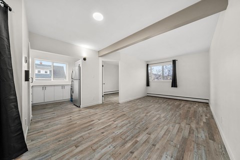A room with wooden flooring and white walls.