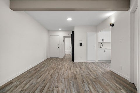 A room with wooden flooring and white walls.