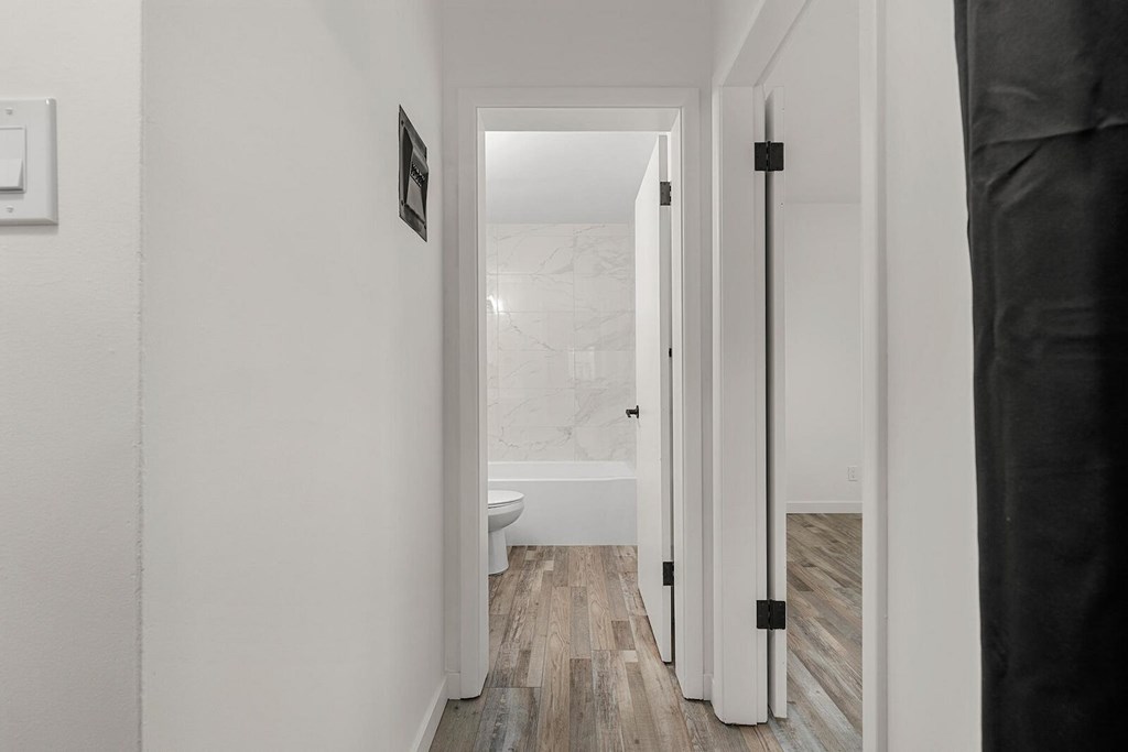 A white hallway with a toilet and a sink.