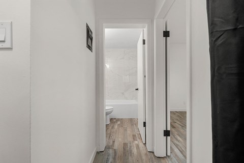 A white hallway with a toilet and a sink.