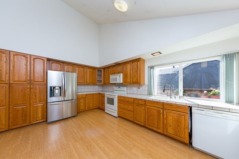 A kitchen with wooden cabinets and a white refrigerator.