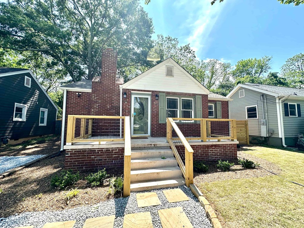 A house with a brick chimney and a wooden deck.