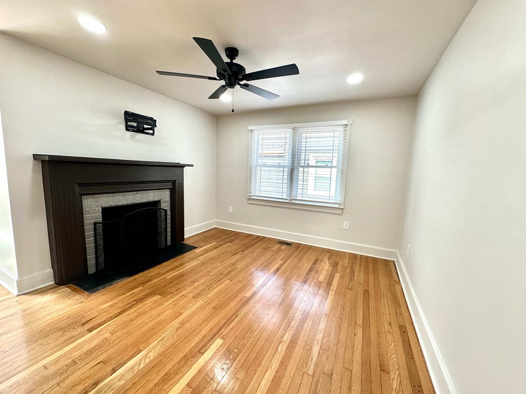 A room with a fireplace and a ceiling fan.