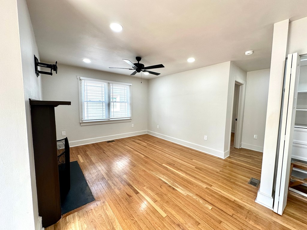 A room with wooden floors and a ceiling fan.