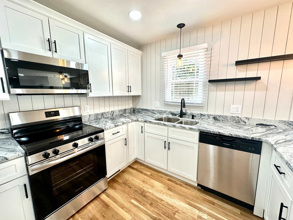 A kitchen with white cabinets and a black stove top oven.