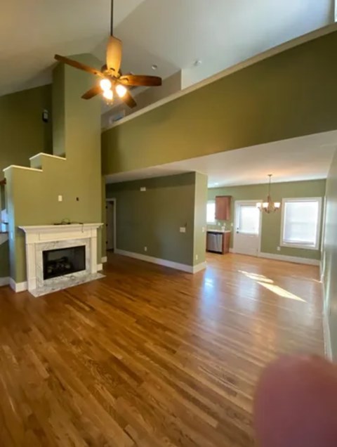 A living room with a fireplace and a ceiling fan.
