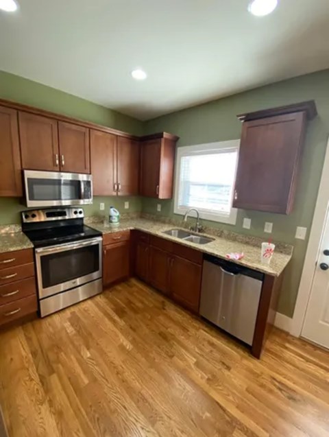 A kitchen with wooden floors and stainless steel appliances.