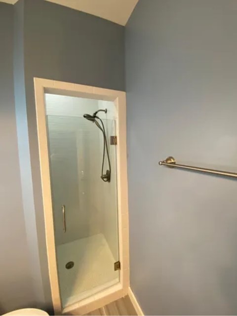 A white shower door in a bathroom.