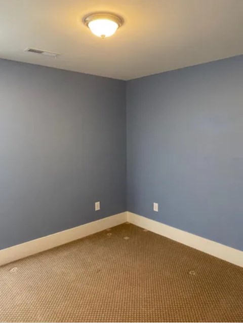 A room with a blue wall and a brown carpet.