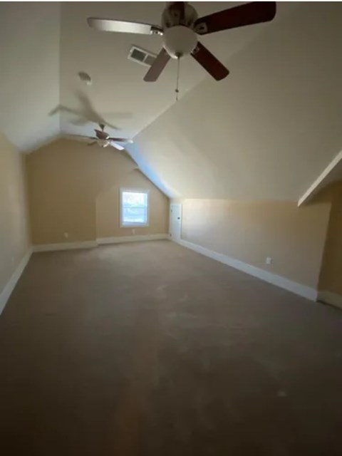 A room with a ceiling fan and a window.