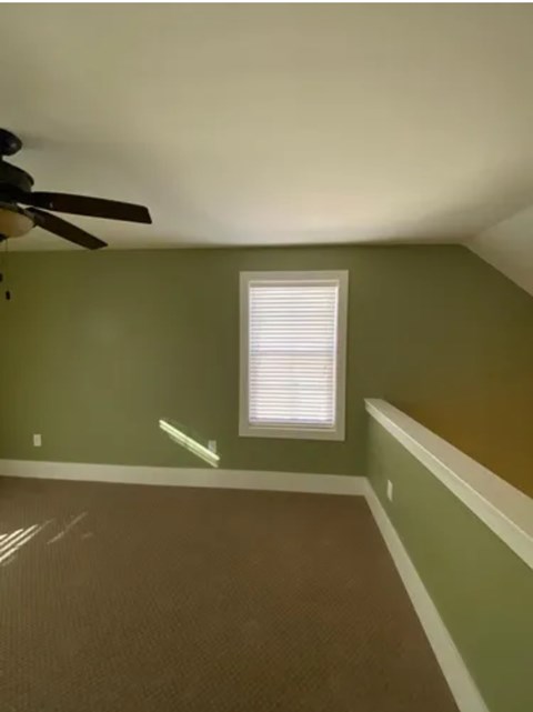 A room with a ceiling fan and a window.