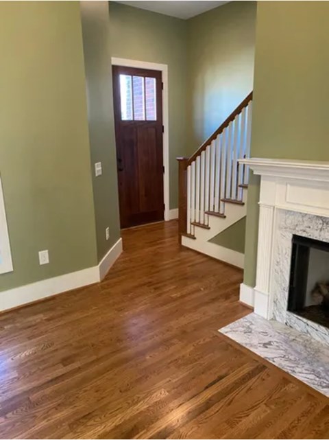 A room with a wooden floor and a fireplace.
