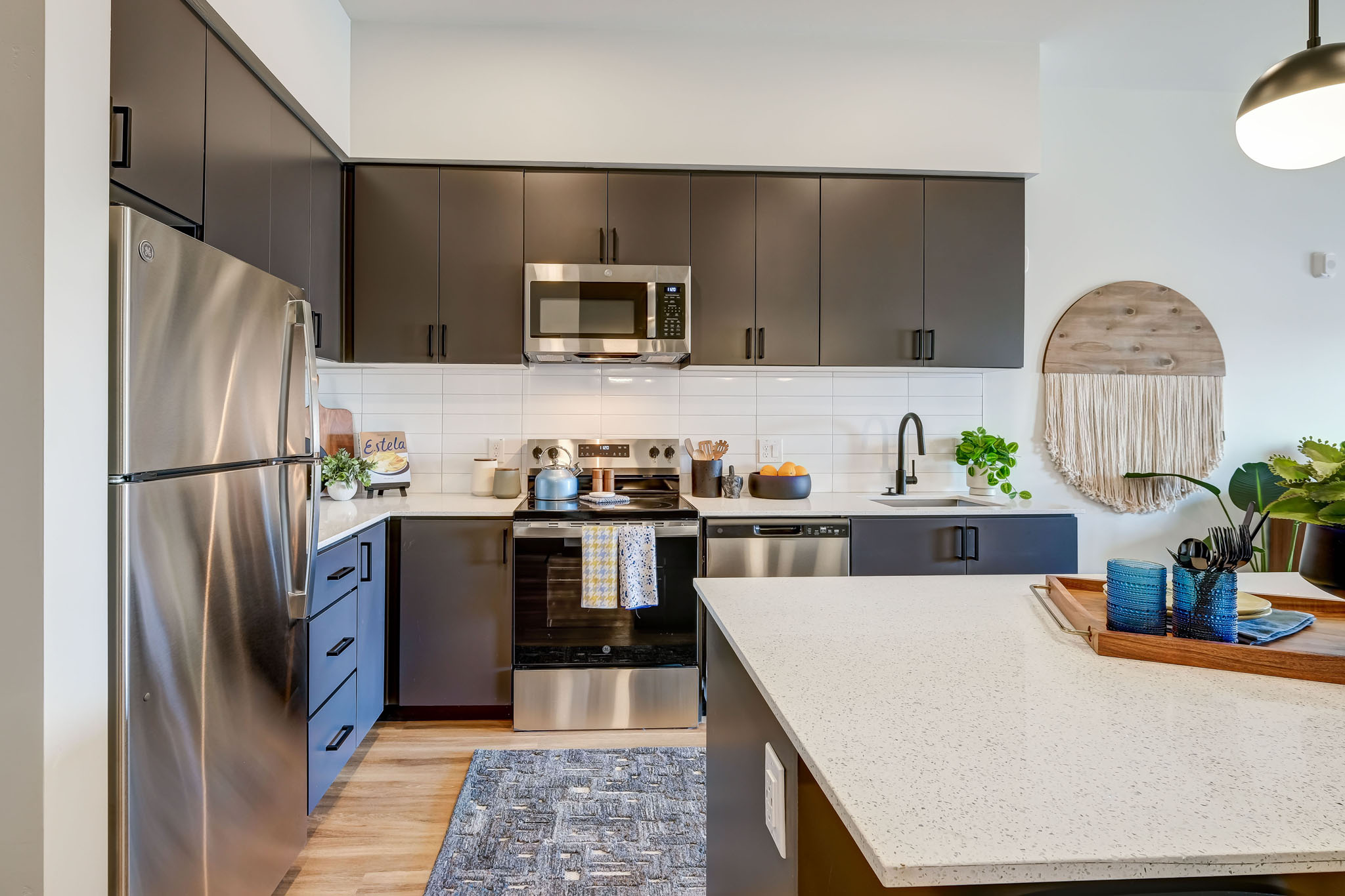 A modern kitchen with a stainless steel refrigerator and dark wood cabinets.