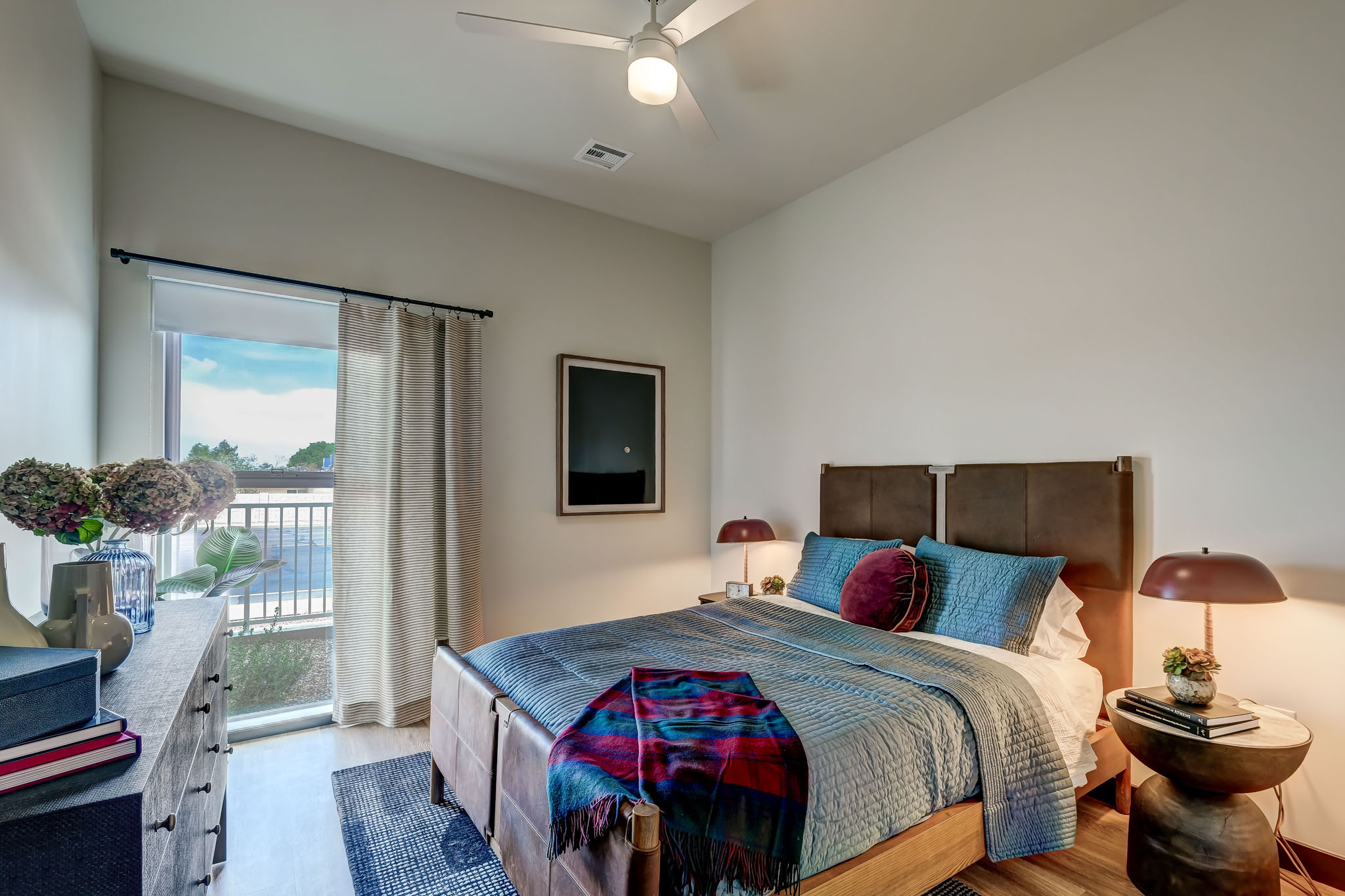 bedroom with queen sized bed and sliding door to balcony