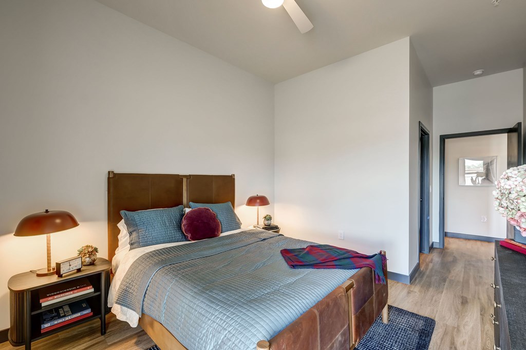 A bedroom with a bed, nightstand, and lamp.