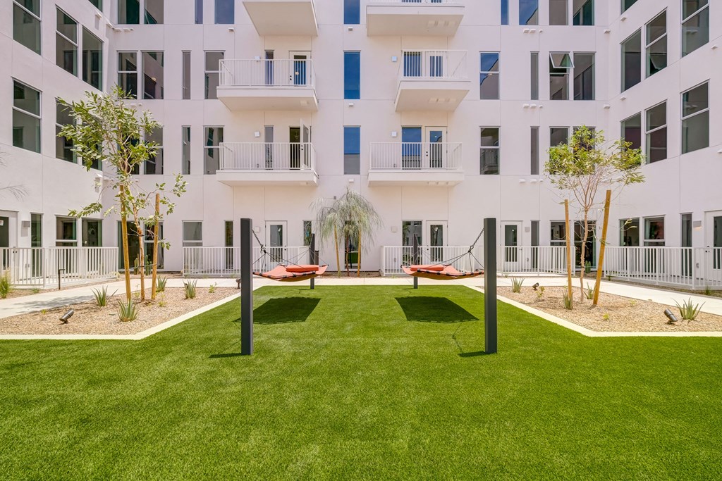 A white building with a green lawn in front.