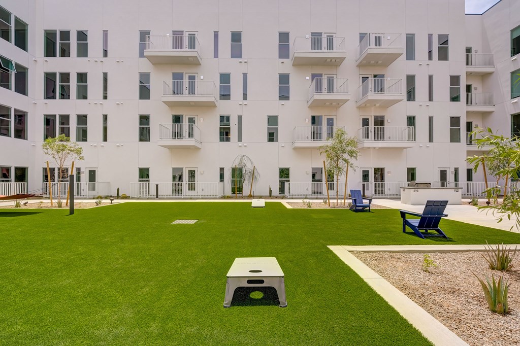A white building with a green lawn in front.