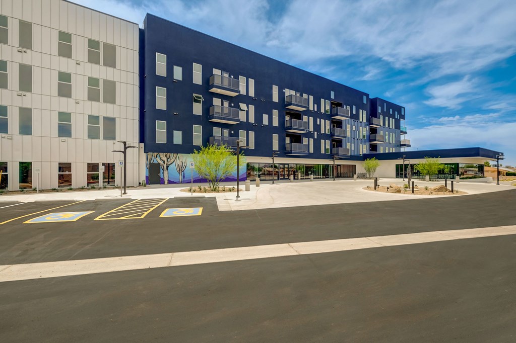 A modern building with a parking lot in front.