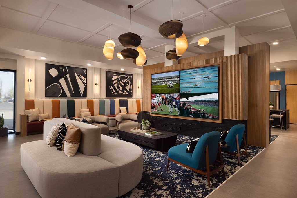 A modern living room with a large TV and comfortable seating.