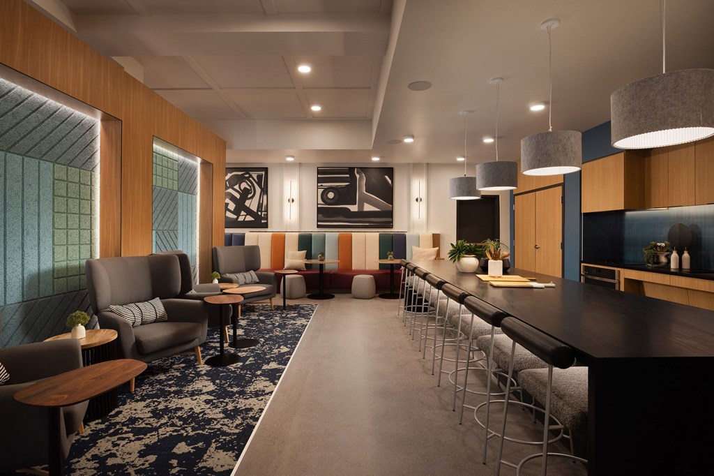 A modern lounge area with a long bar and comfortable seating.