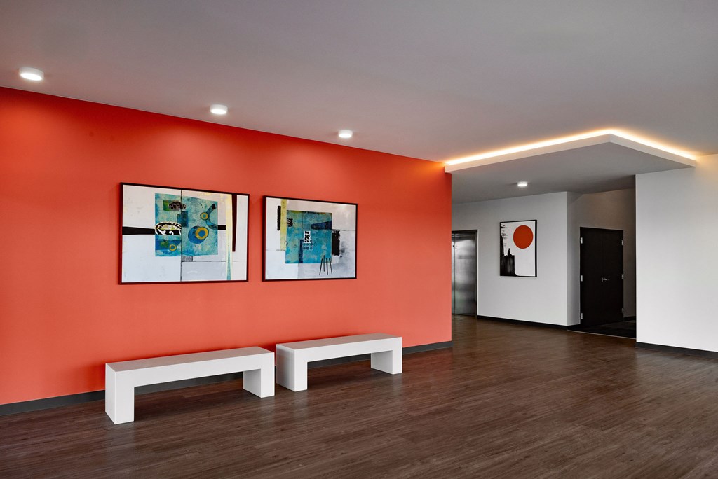 A room with orange walls and two white benches.