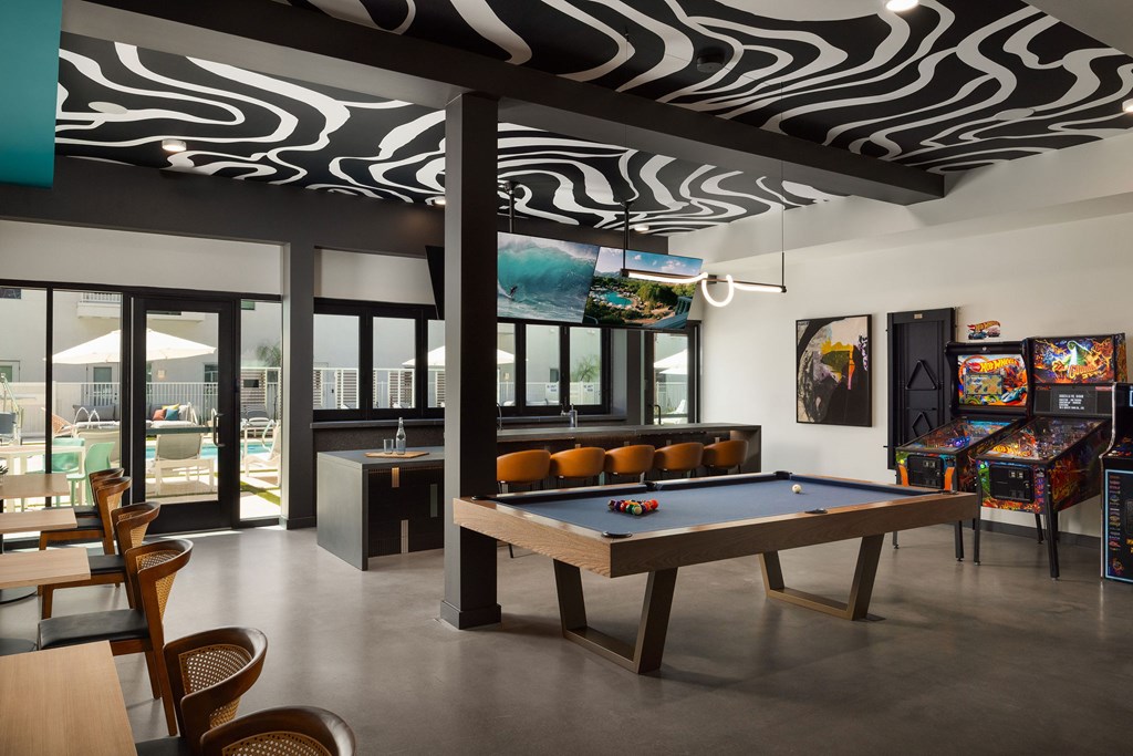 A room with a pool table and a zebra print ceiling.