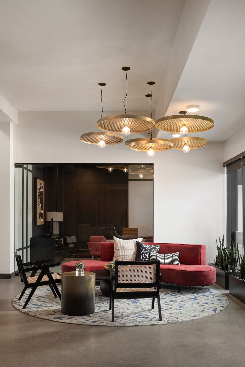 A living room with a red couch and a black chair.