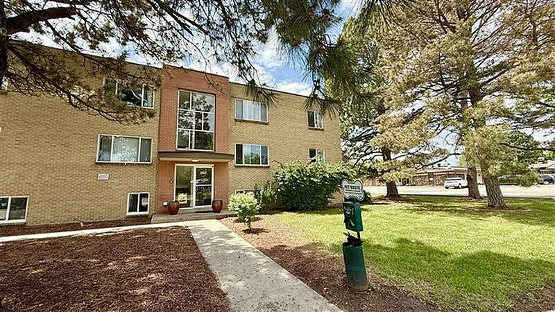 A brick building with a tree in front.