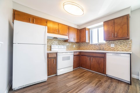 A kitchen with wooden cabinets and a white refrigerator.