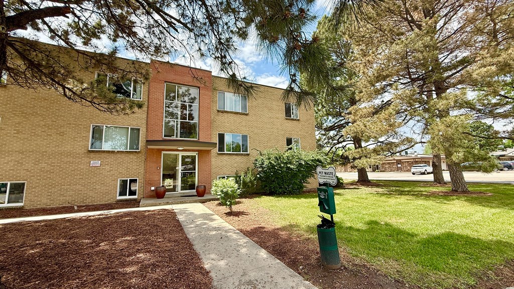 A brick building with a green pole in front of it.