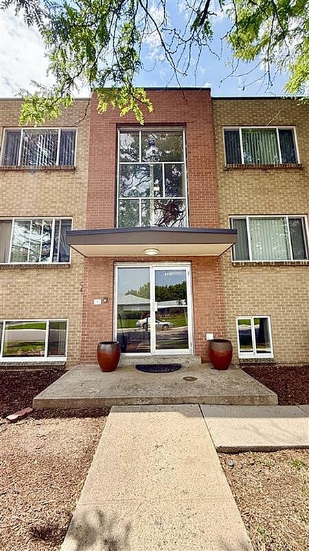 A brick building with a glass door and windows.