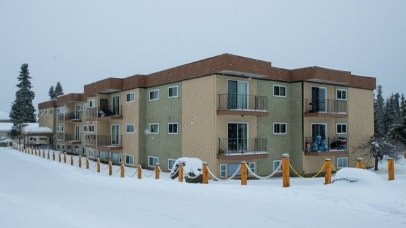 Apartment building with a white van parked in front.