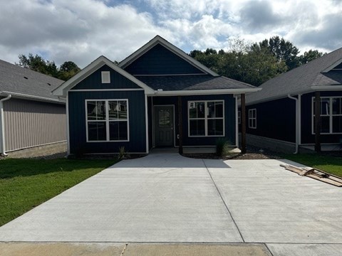 A blue house with a grey roof and a grey garage door.