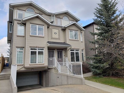 A two-story house with a garage and a balcony.