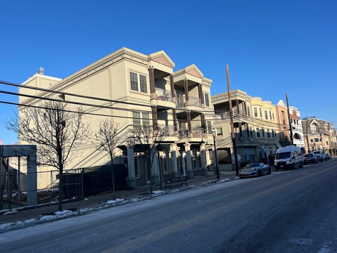 A row of buildings with a car parked on the street.
