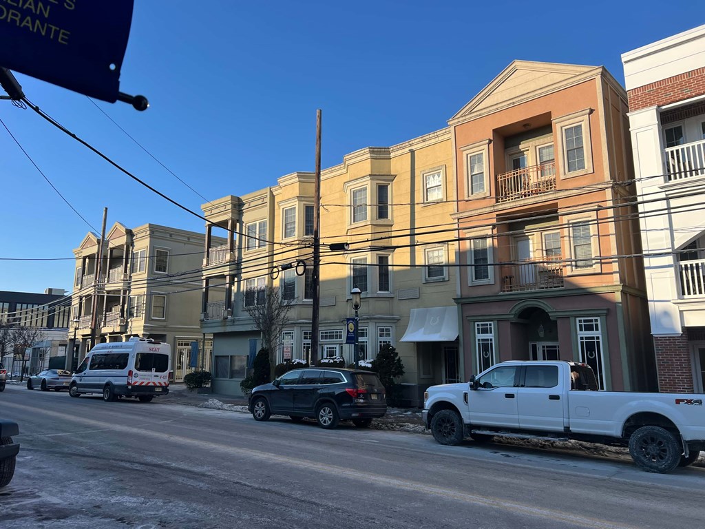 A street scene with a white truck parked on the side of the road.