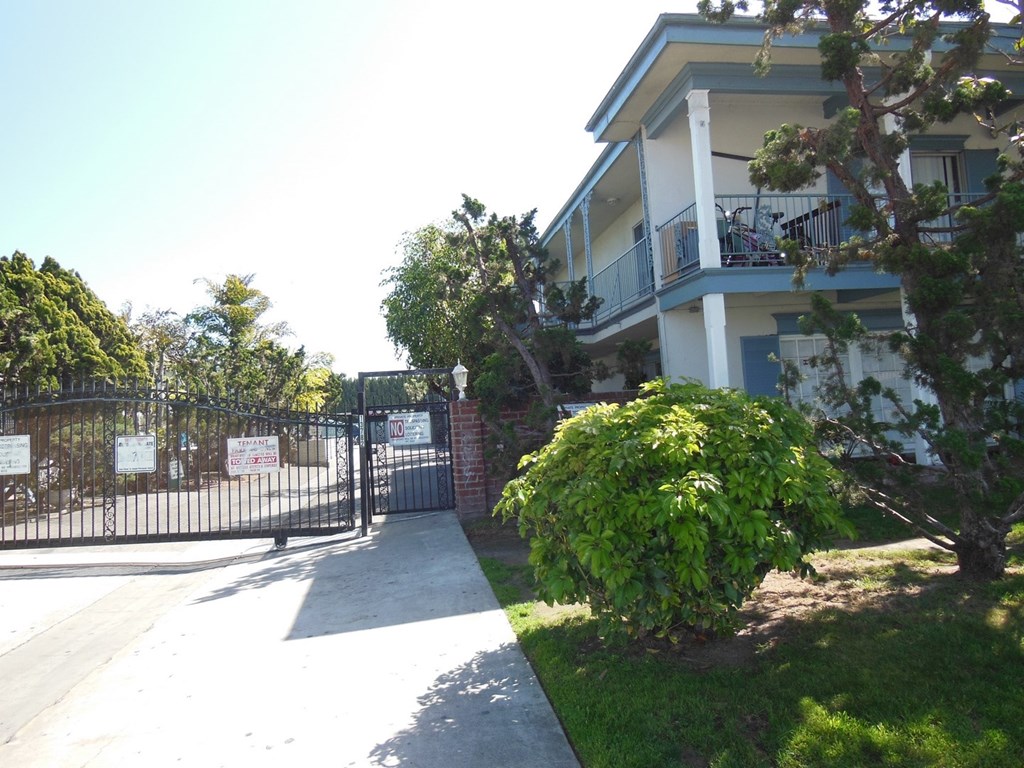 A gated entrance to a building with a sign on the gate.