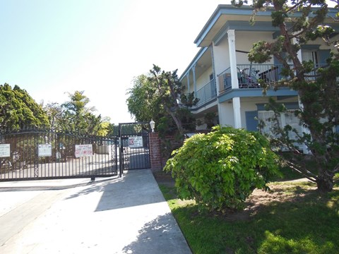 A gated entrance to a building with a sign on the gate.