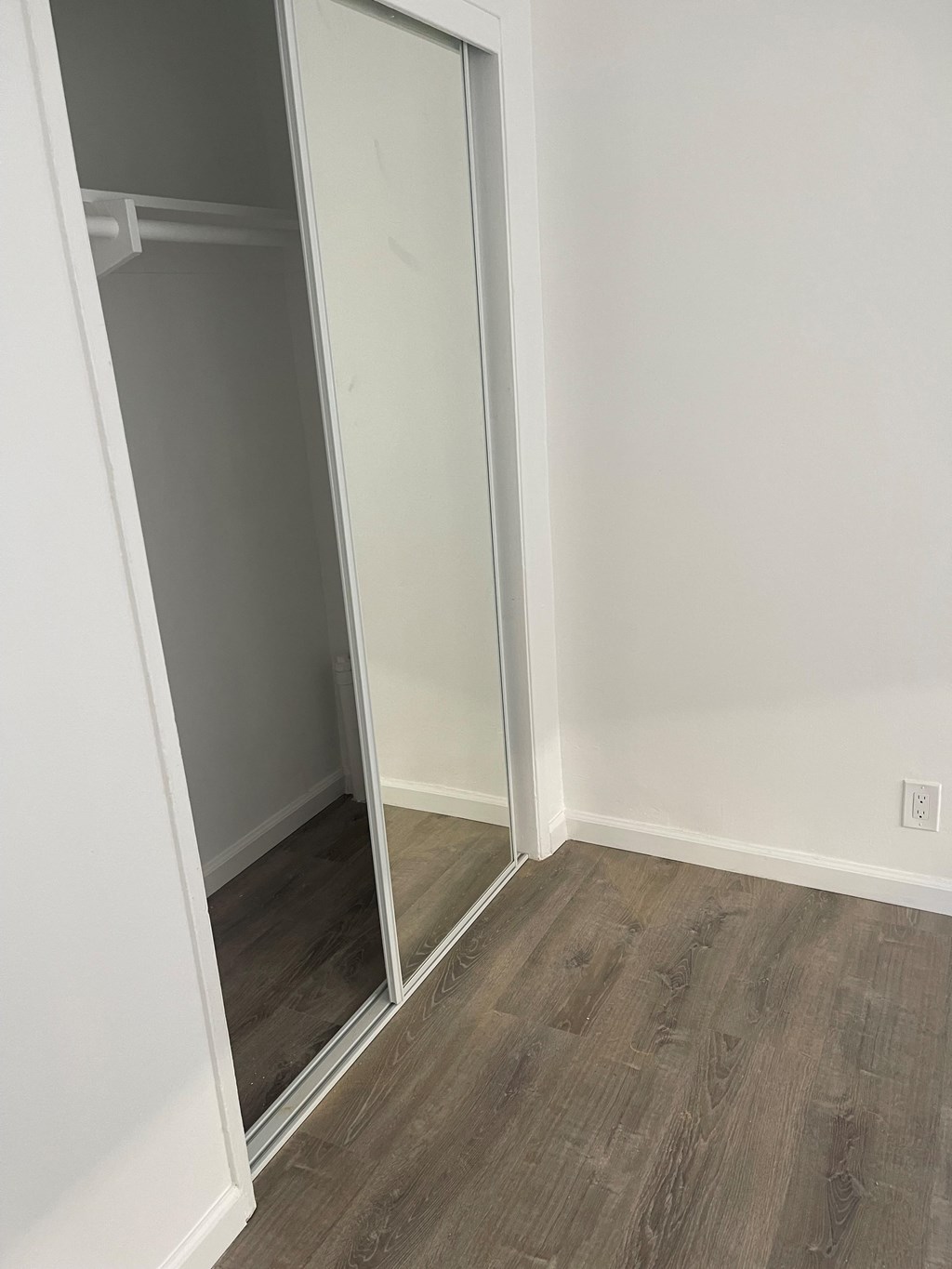 A room with a white wall and a wooden floor.