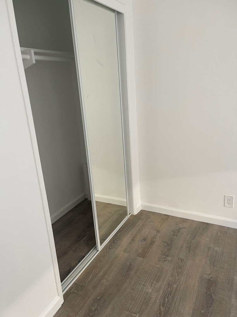 A room with a white wall and a wooden floor.