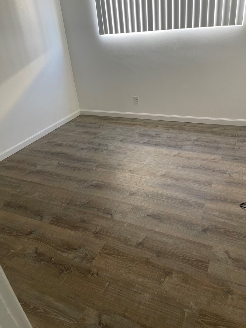 A room with a wooden floor and a window.