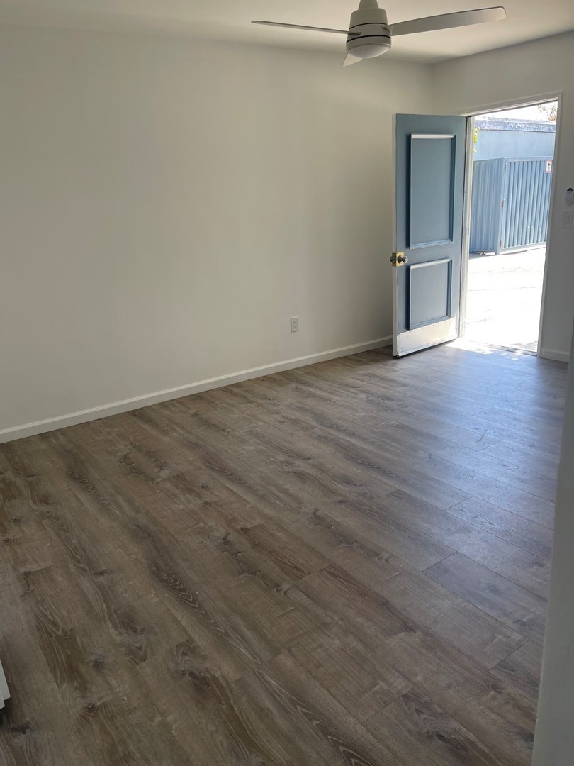 A room with a light wooden floor and a blue door.