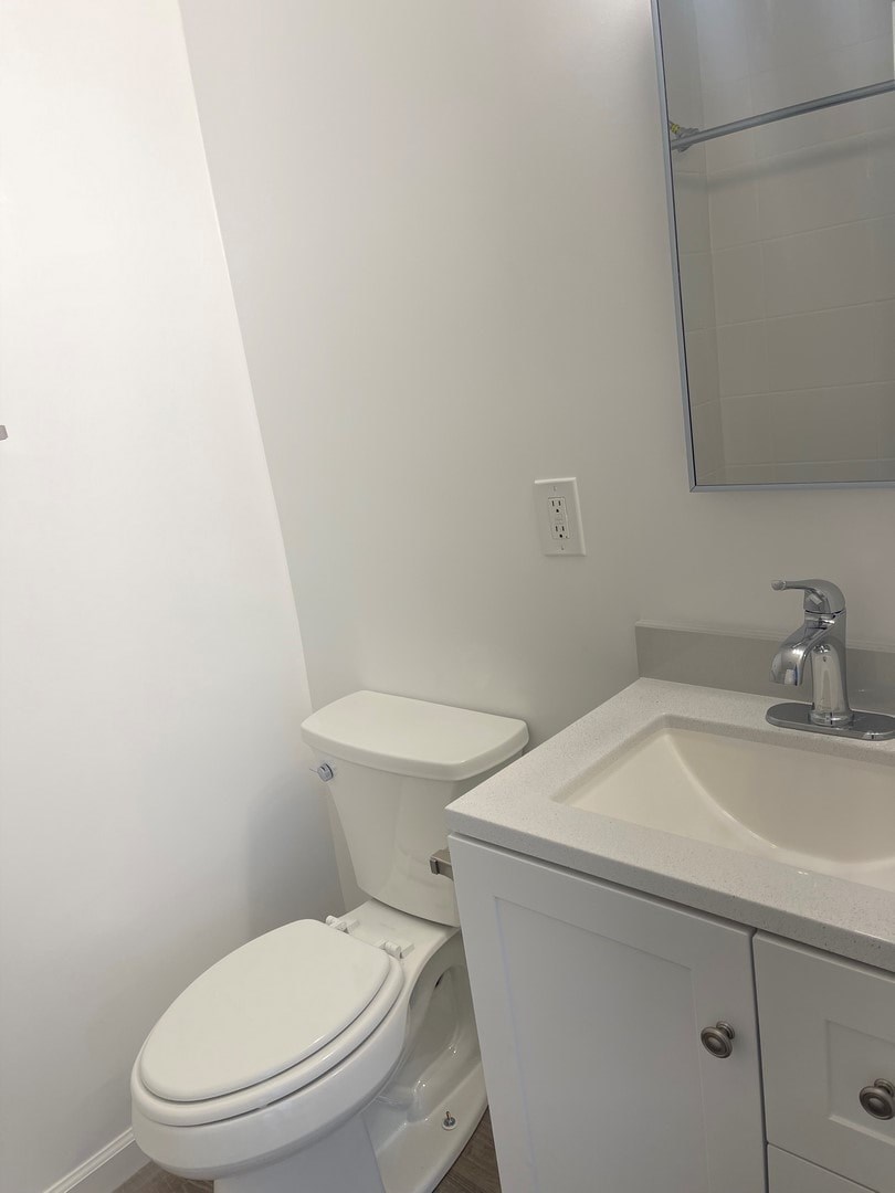 A white toilet sits next to a sink in a bathroom.