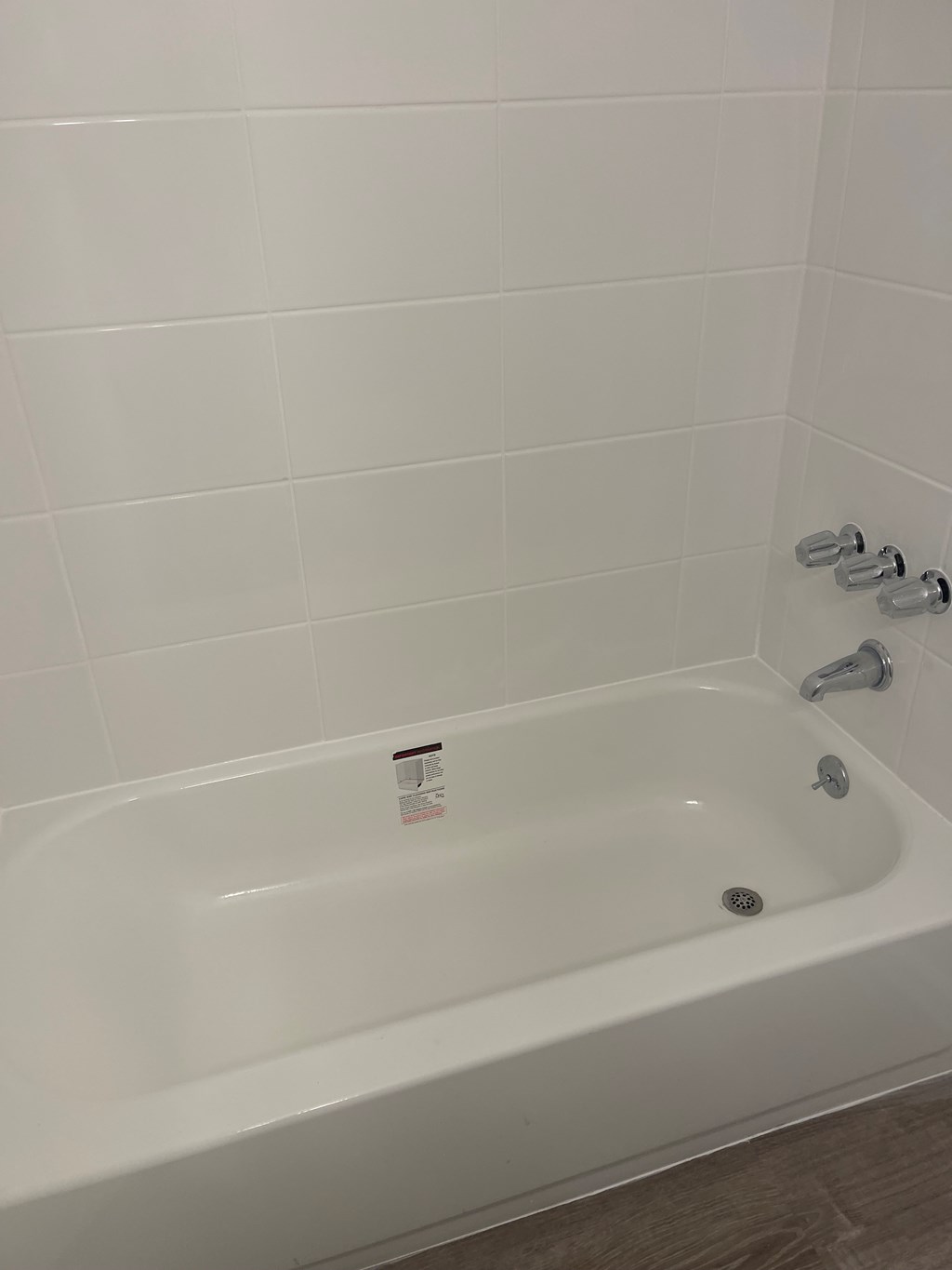 A white bathtub with a shower head and a faucet.
