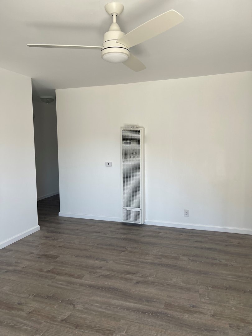 A room with a ceiling fan and a wall-mounted air conditioning unit.