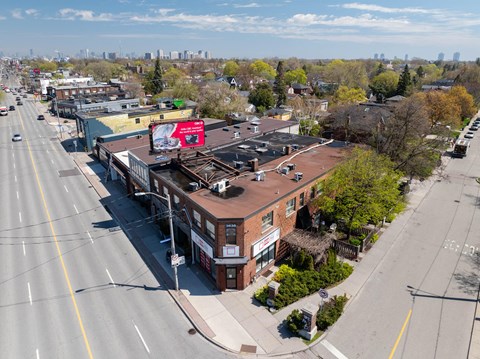 A city street with a red billboard on a building.