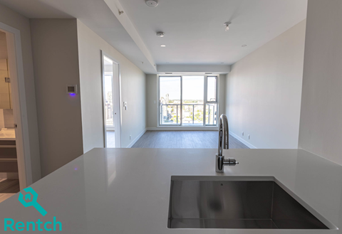 A kitchen with a black counter top and a sink.